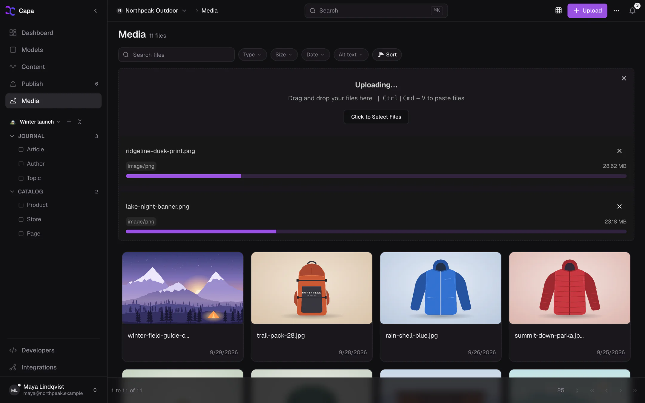 The Upload files panel over the media grid, with two files uploading